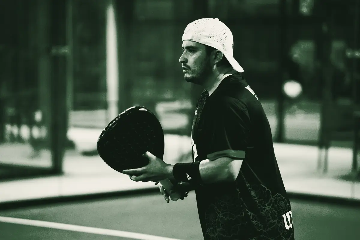 A player in a cap holding his paddle before a match