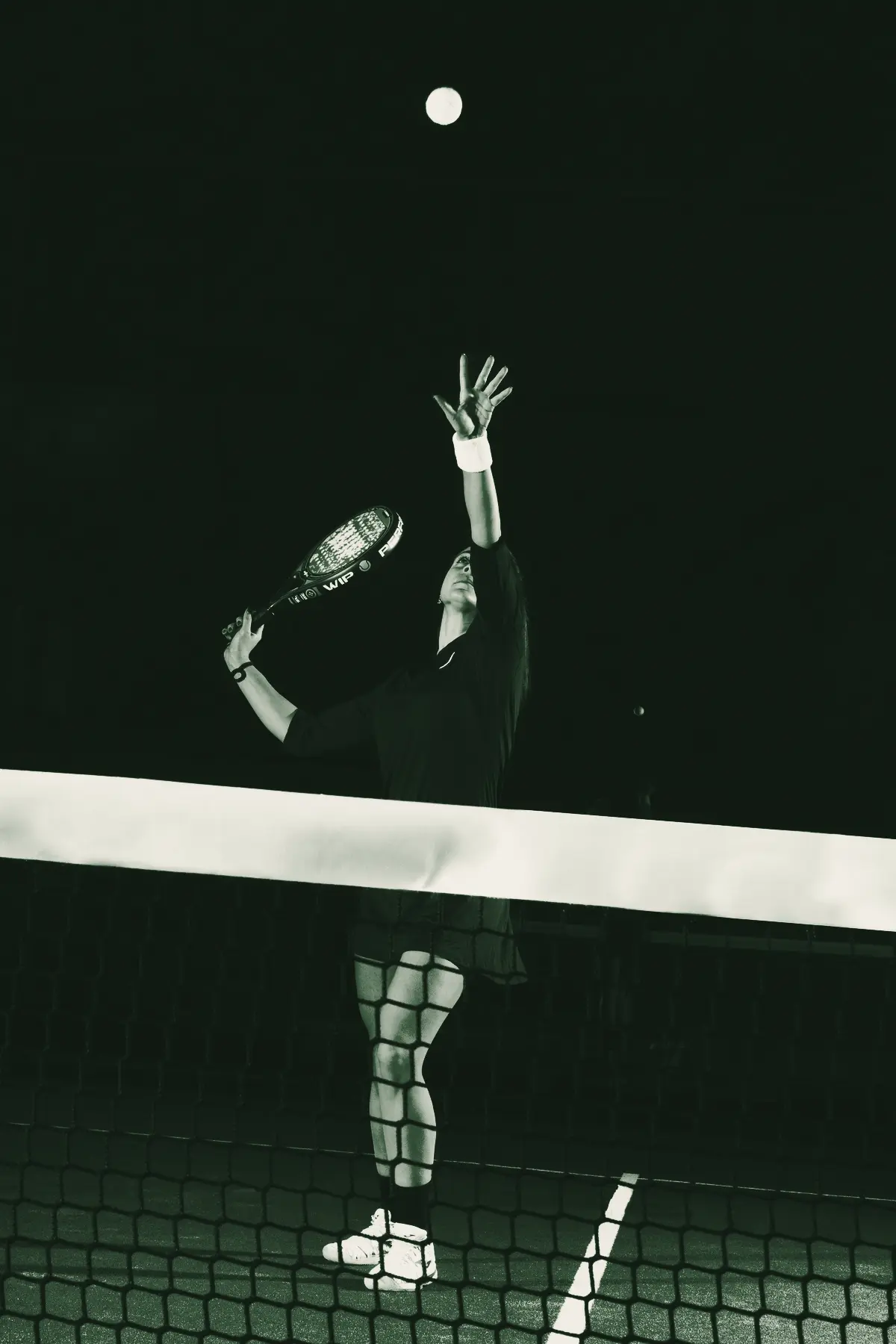 A player reaches for a lob under the night sky